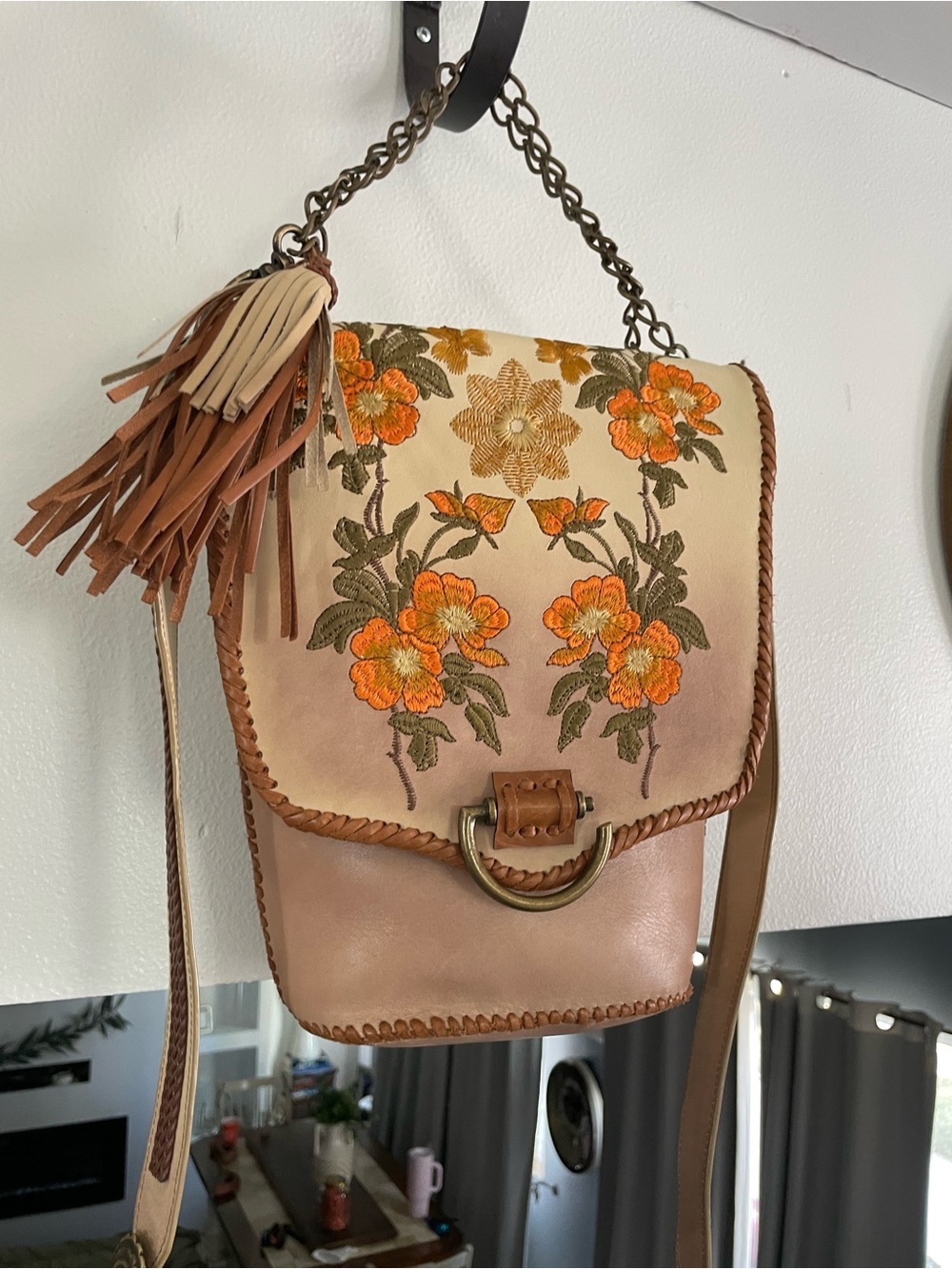 Artisan structured leather handbag features intricate floral embroidery
